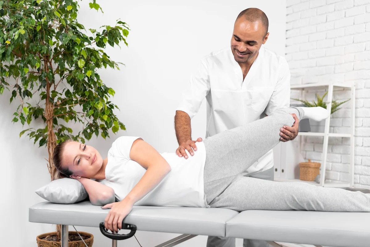 Chiropractor checking range of motion on hip joint before chiropractic care