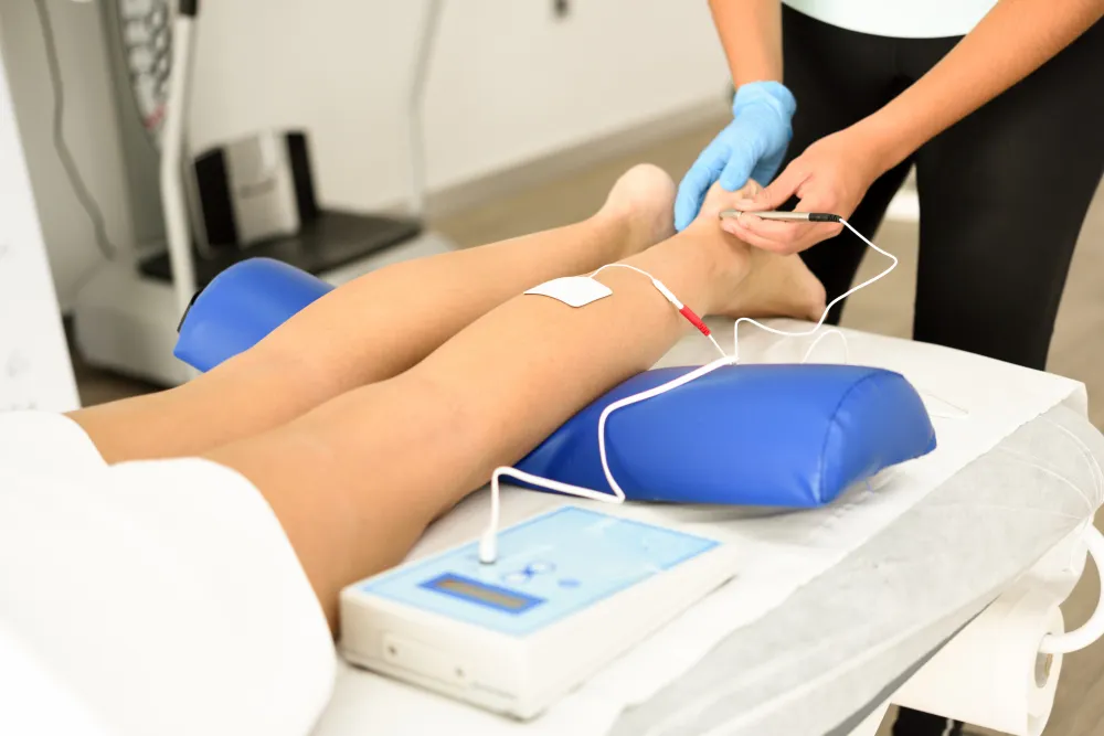 E-stim therapy on chiropractic patient’s leg in Crawfordsville IN