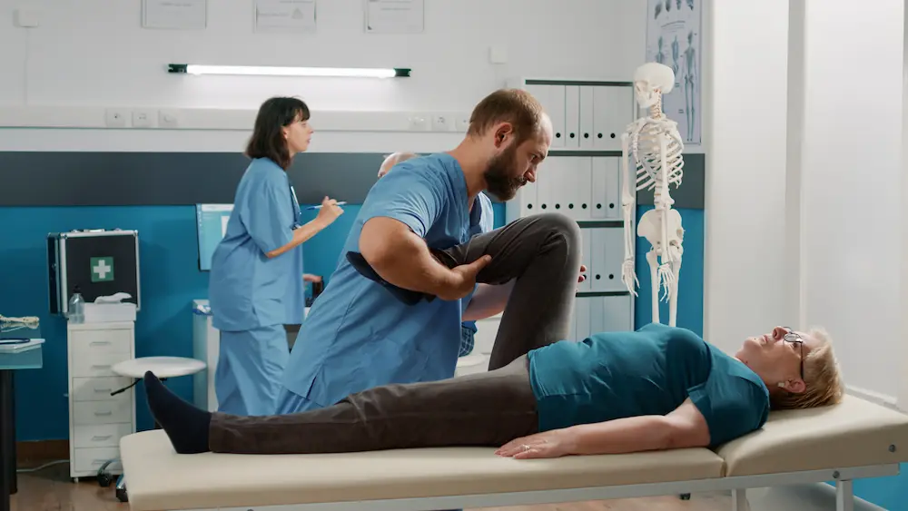 Chiropractor assisting patient after surgery to improve mobility and support recovery