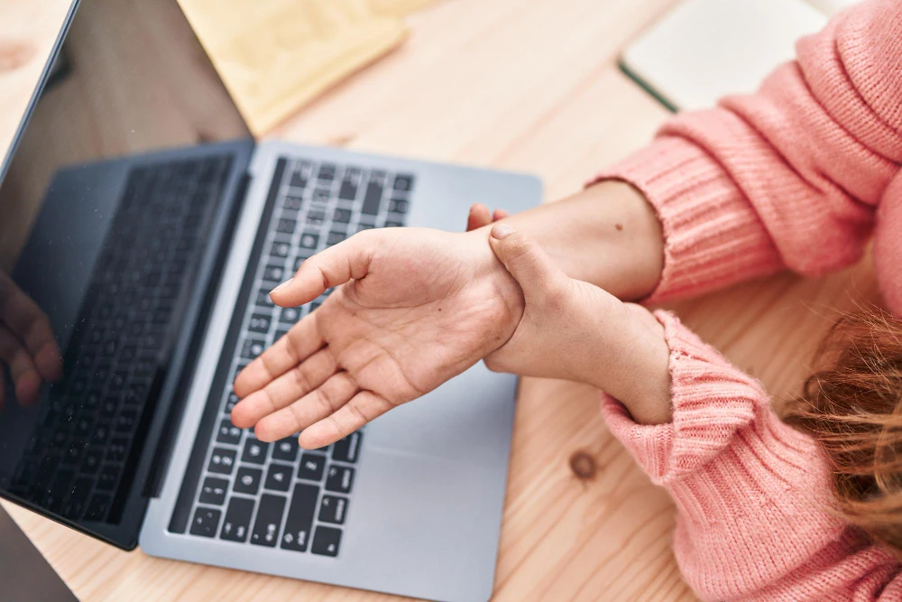 Person experiencing wrist pain from carpal tunnel syndrome