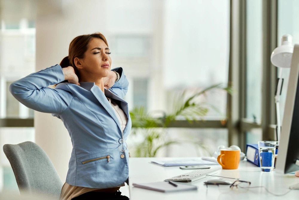 Woman feeling dizzy and holding head while at work