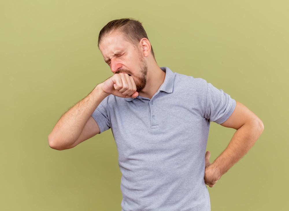 Person experiencing lower back pain while coughing or sneezing