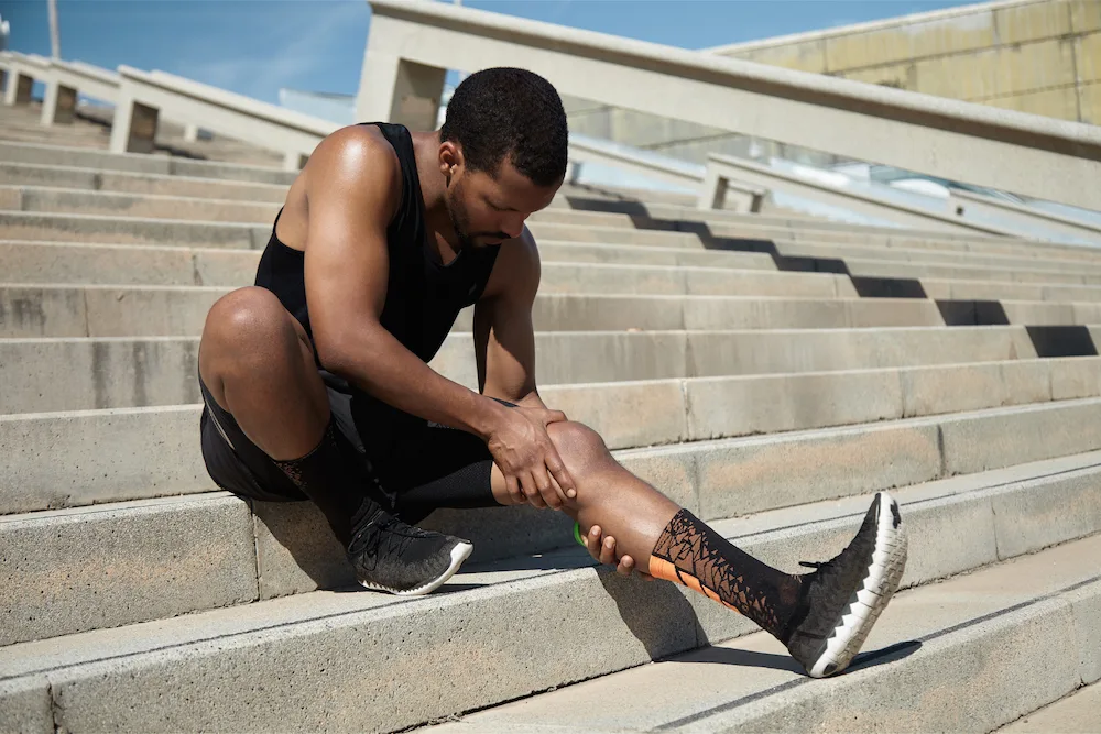Athlete holding an injured leg or ankle after a sports activity